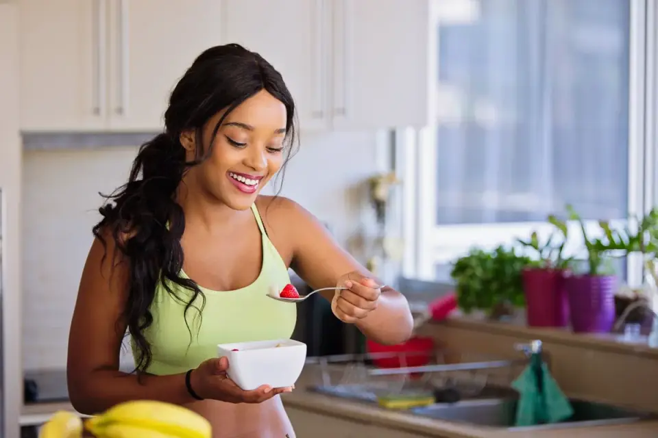 A dog eating a meal from a stainless steel bowl in a home kitchen