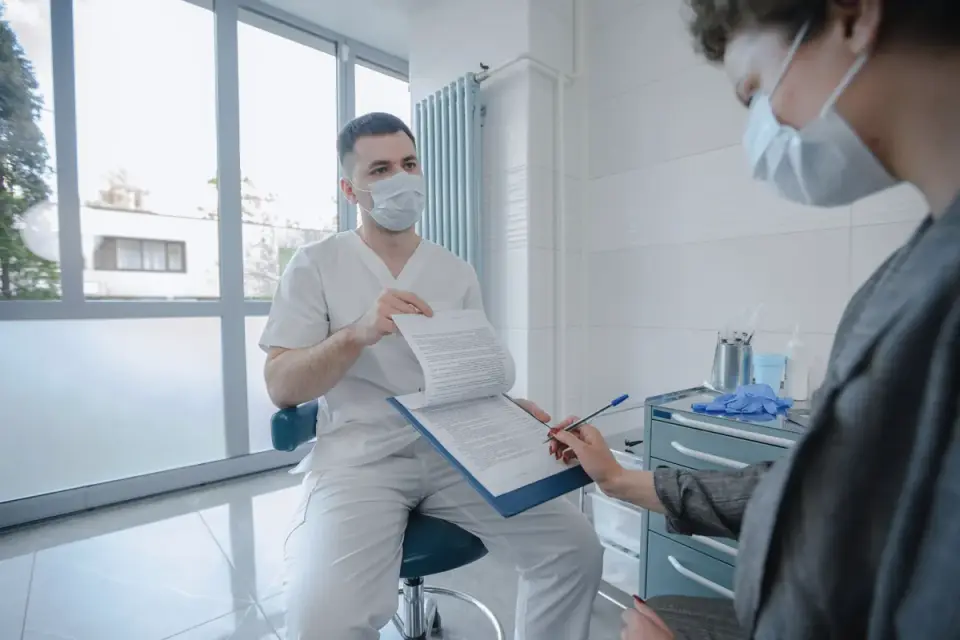 A veterinarian and dog owner reviewing a supplement label together in an exam room