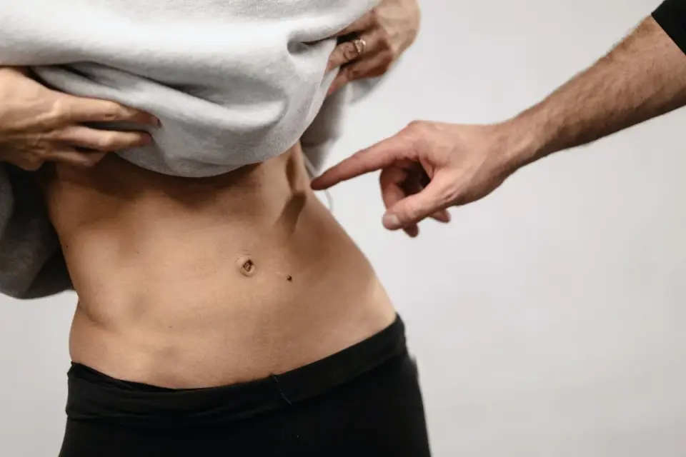 A veterinarian gently pressing on a dog&#x27;s abdomen during a physical exam