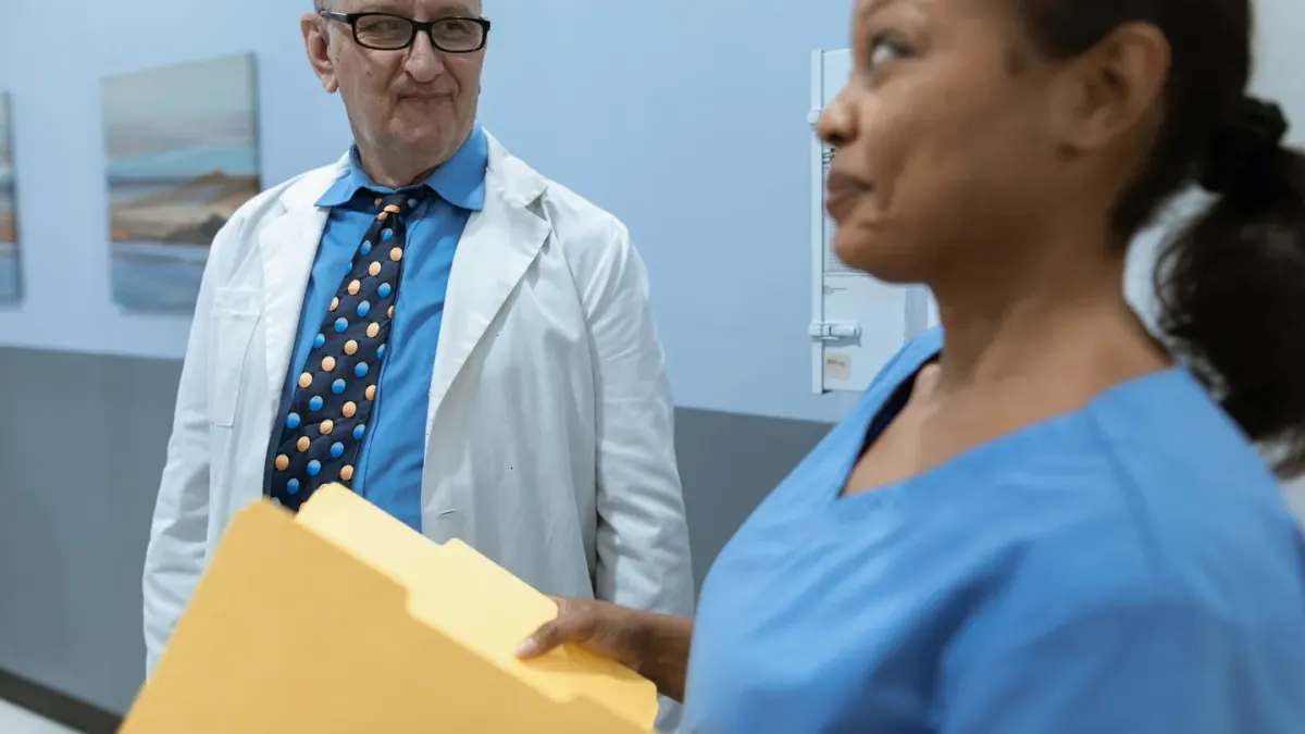 A veterinarian reviewing bloodwork printouts next to a senior dog on an exam table